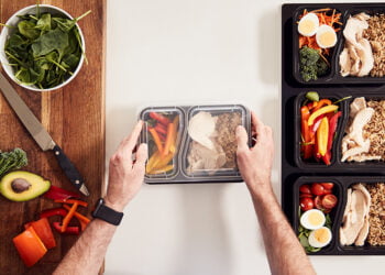 Overhead Shot Of Man Preparing Batch Of Healthy Meals At Home In Kitchen